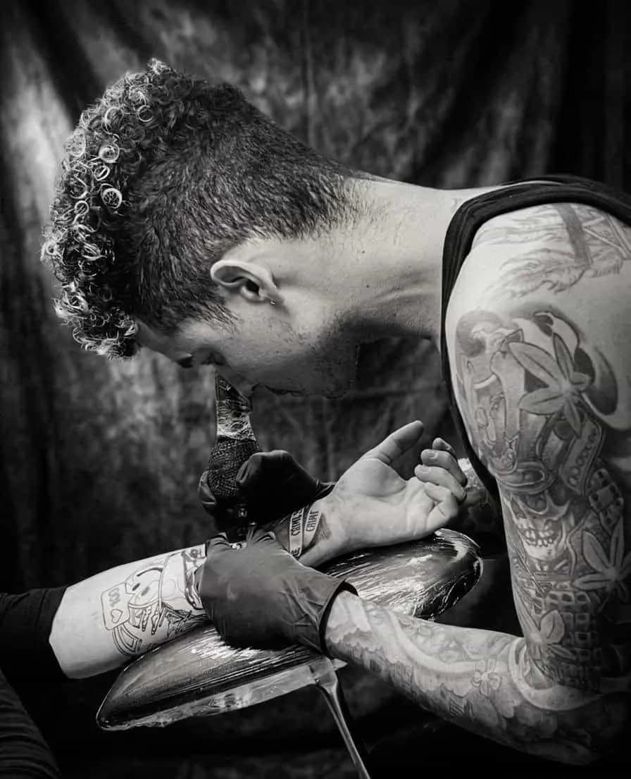 Fernando Tattoo tatuando en su estudio de Tapachula, fotografía en blanco y negro